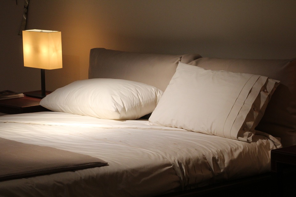 A bed illuminated by the soft glow of a lamp. Great for sleeping!