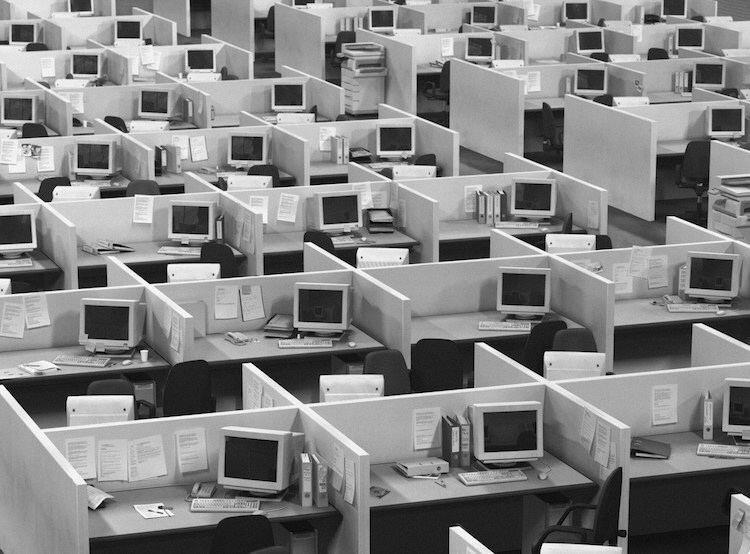 Rows and rows of bland cubicles representing dreary office work.